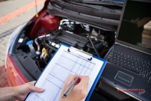 mechanic performs car inspection with clipboard