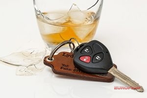 a photo of car keys next to an alcoholic beverage